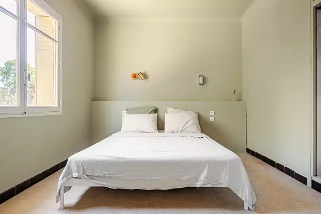 Chambre lit double aux murs clairs