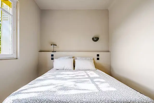 Chambre lit double, murs blancs