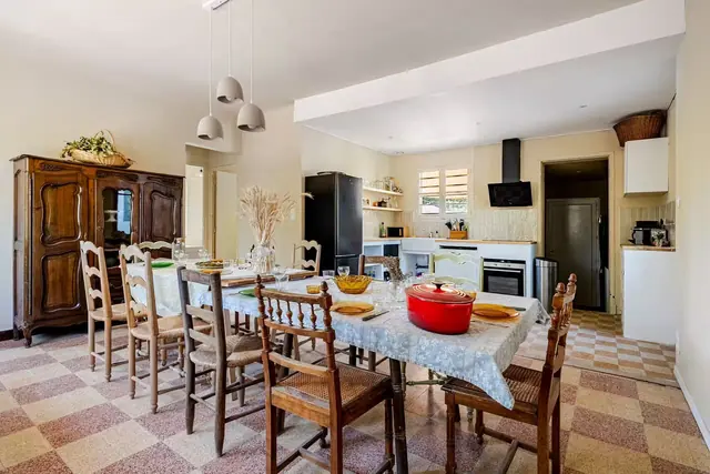 Grande table dressée et cuisine ouverte